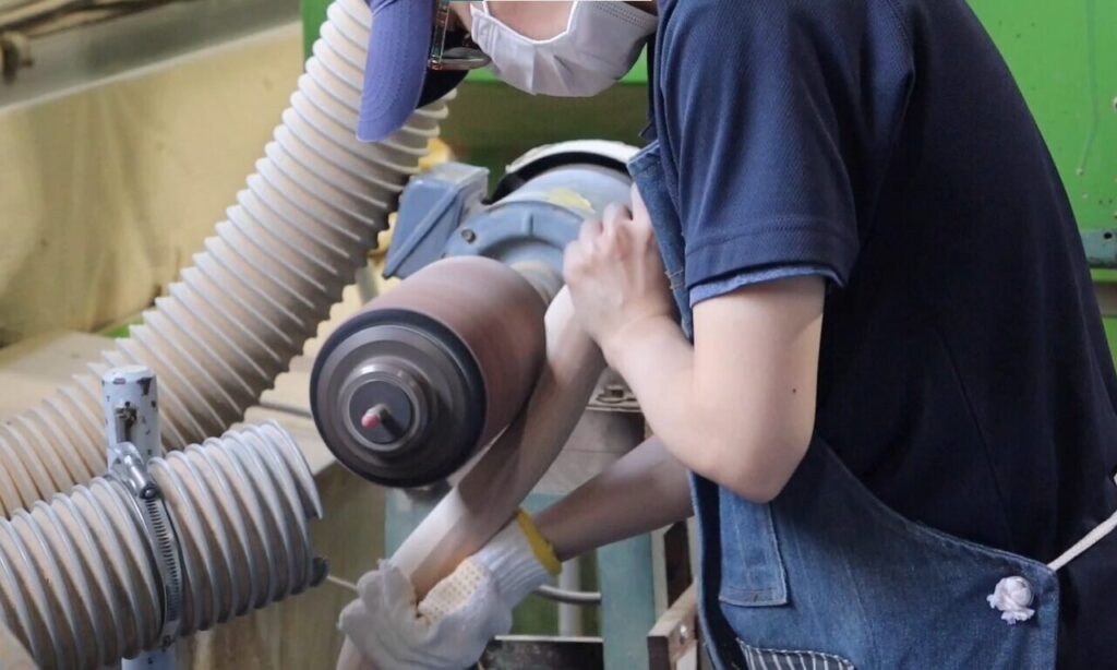 株式会社スズハルで木材のR面をサンディングしている作業風景