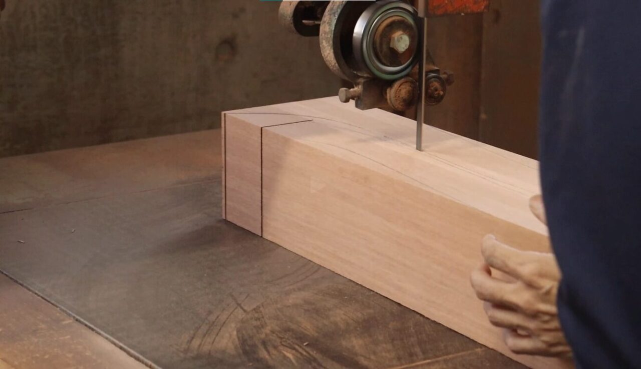 Cutting material to required size using a bandsaw. The material is Mato wood, and the company also has a 2-axis planer lathe for larger items besides the coping machine shown.