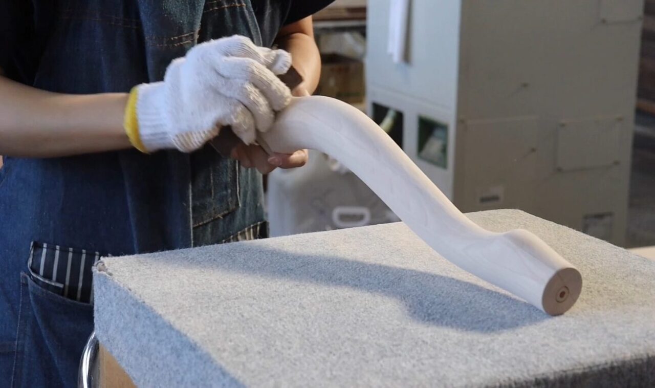 Hand finishing process: Final surface inspection and finishing of wood lathe machined parts.