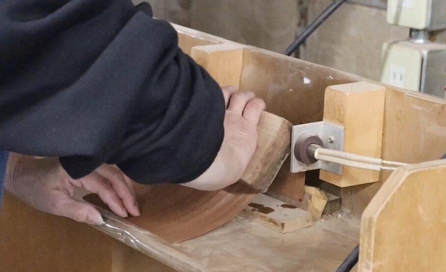 Veneer bending process: Wet veneer being bent using heat.