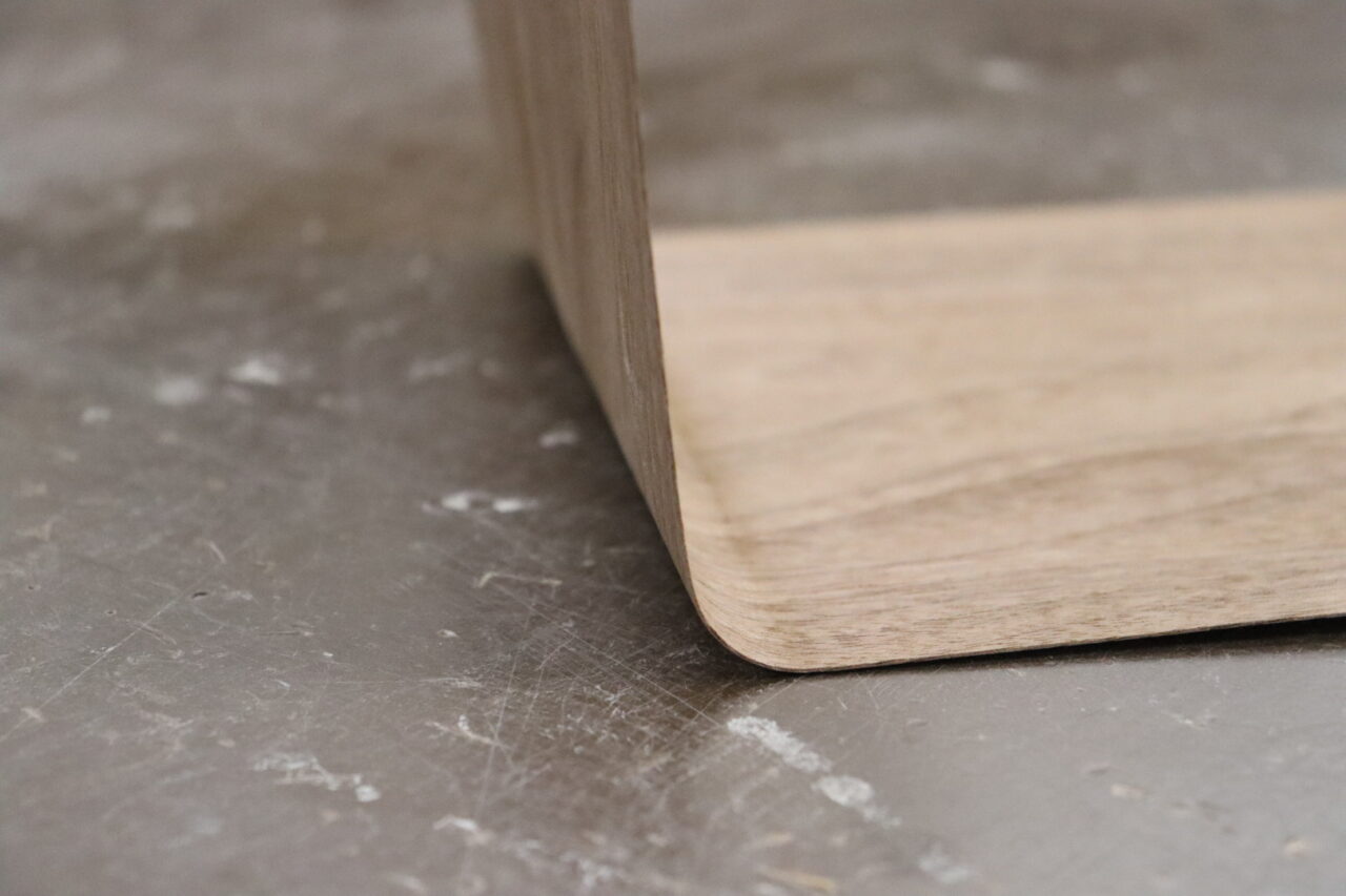 Veneer sheet being bent using heat after being moistened with water.