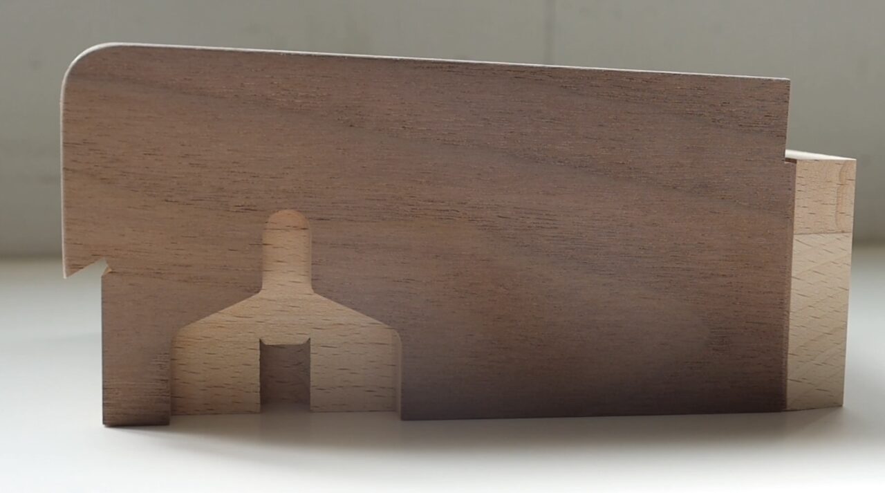 Finished piano part featuring veneer application, showcasing intricate wood grain"