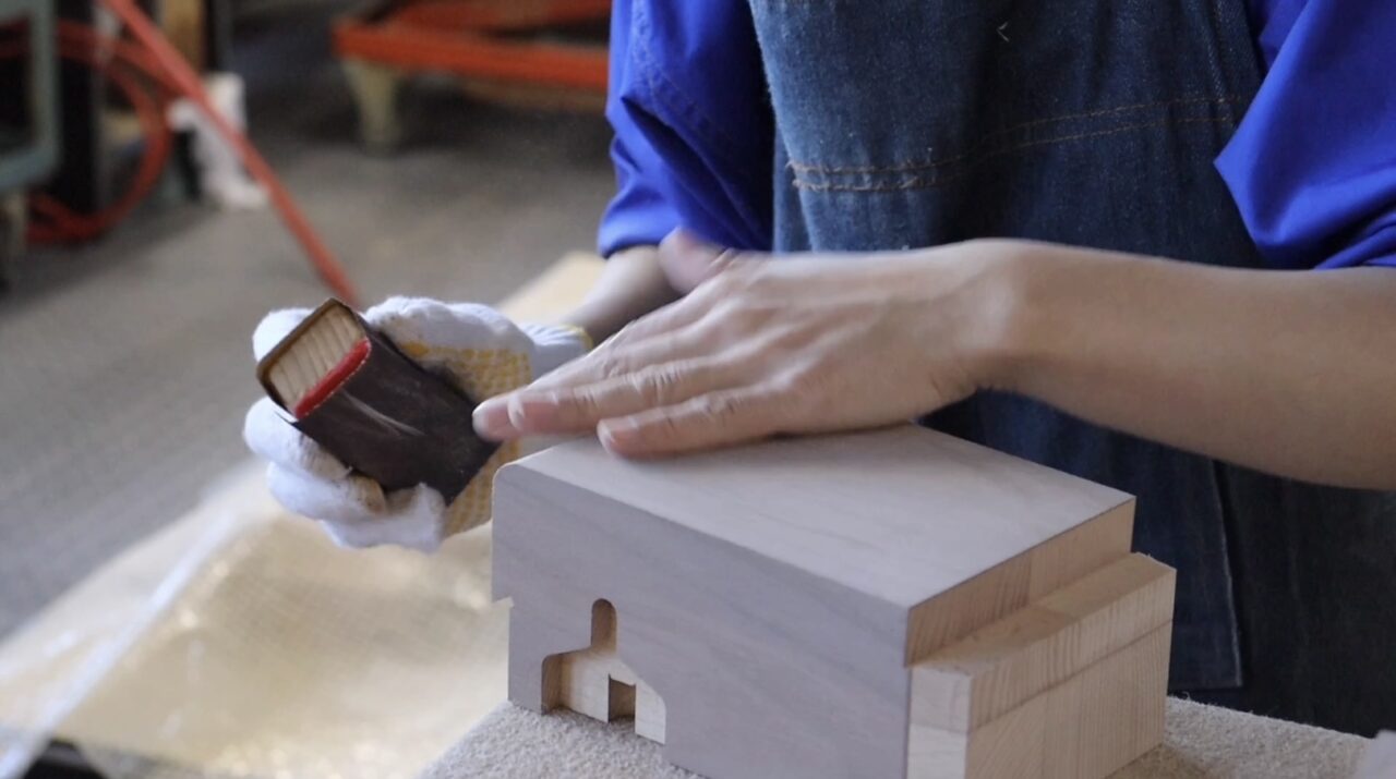 Hand finishing process of veneer - Sanding and smoothing the surface with paper.