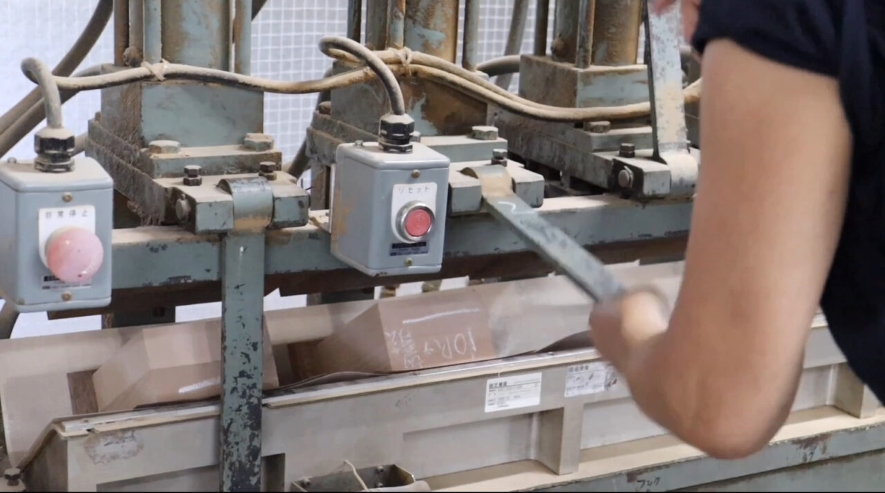 Veneer heat pressure bonding process: A woodwork piece is fixed in a jig and heated to press out excess adhesive, resulting in a smooth and even surface.