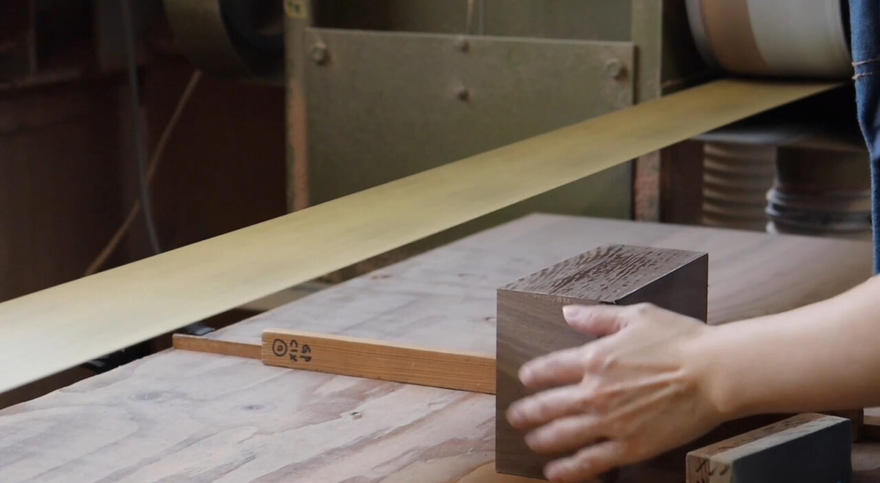 Wood sanding process using a belt sander to reveal the grain pattern.