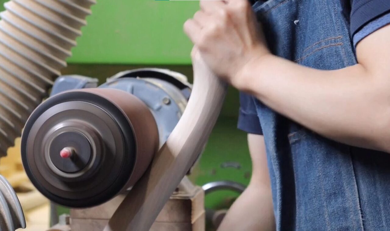 Sanding process using a spindle sander with different grits of paper to finish the surface.