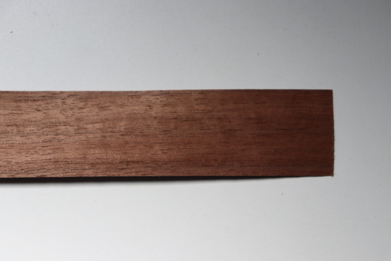 High-quality walnut veneer showcasing the rich texture and grain pattern, popular for furniture due to its durability and resistance to scratches.
