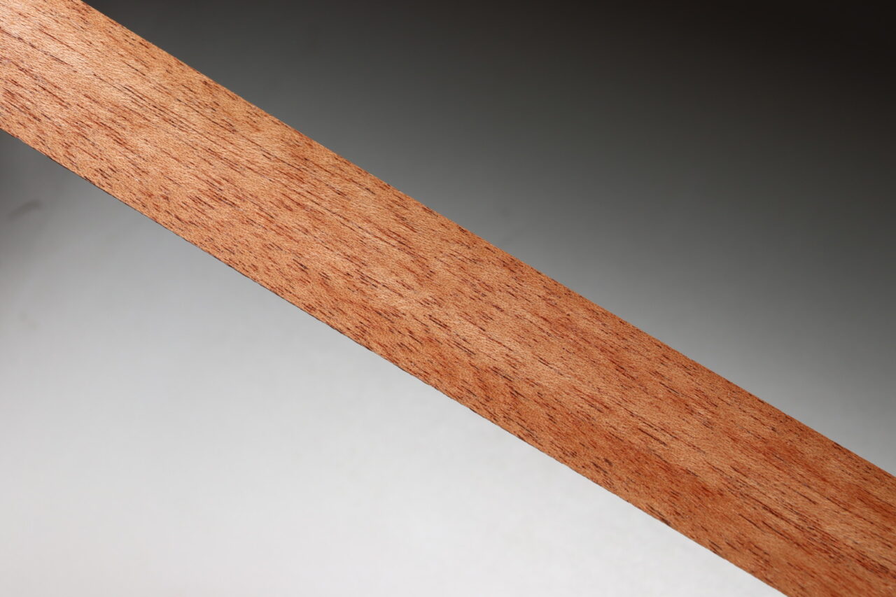 Sapele veneer showcasing distinctive ribbon grain pattern with varying shades, used in exterior, interior, and musical instrument applications. The wood's moderate hardness makes it easy to process and enhances the beauty of the grain.