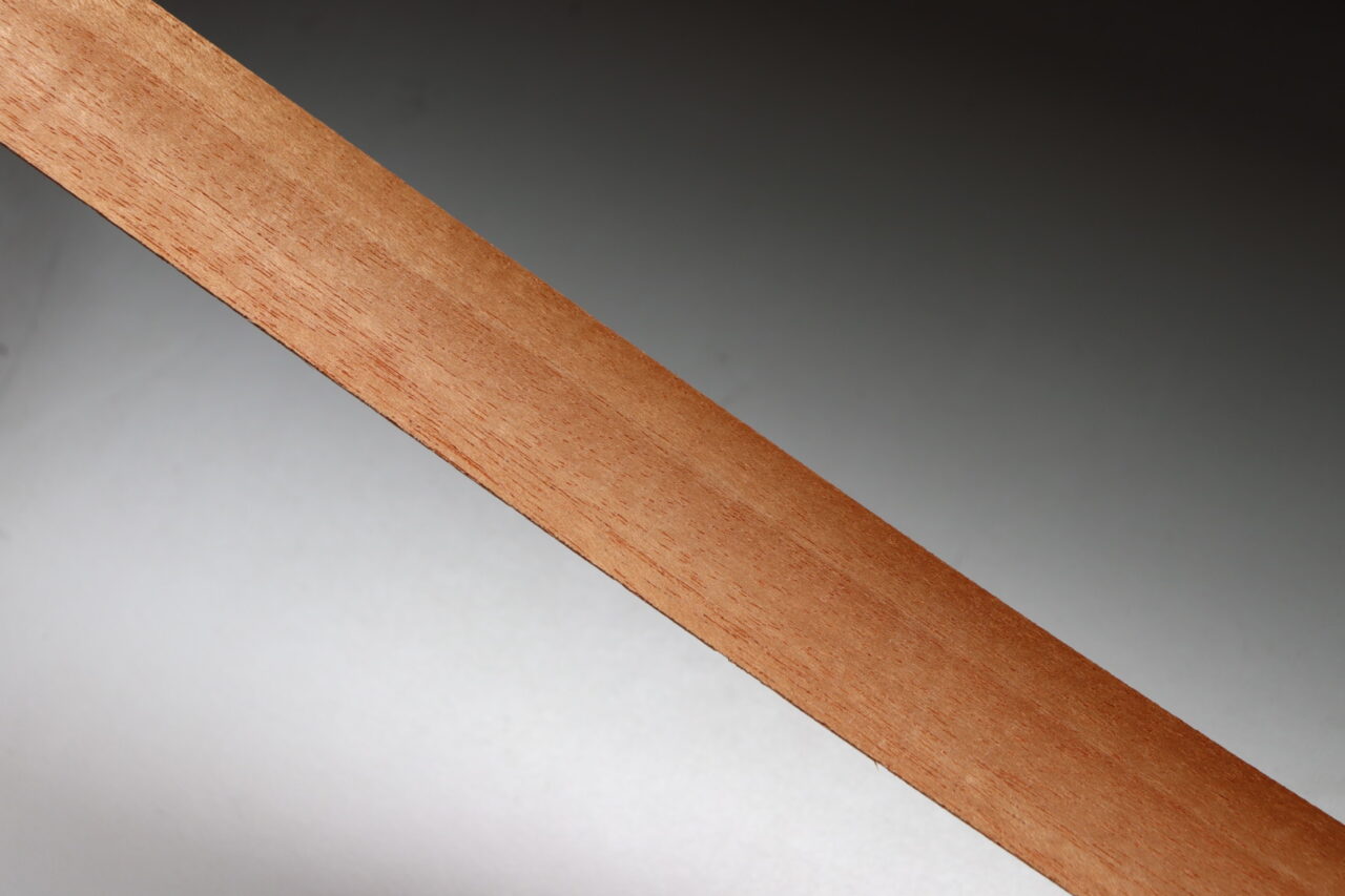 Mahogany wood with natural shine and fine grain, ideal for high-quality furniture and musical instruments.
