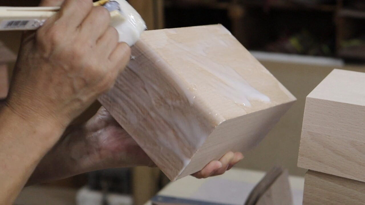 Applying adhesive evenly on the surface of the product to ensure complete coverage before further processing.