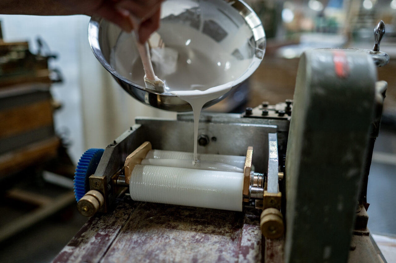 Spreaders (gluing machines) applying adhesive to long wood pieces in a woodworking process
