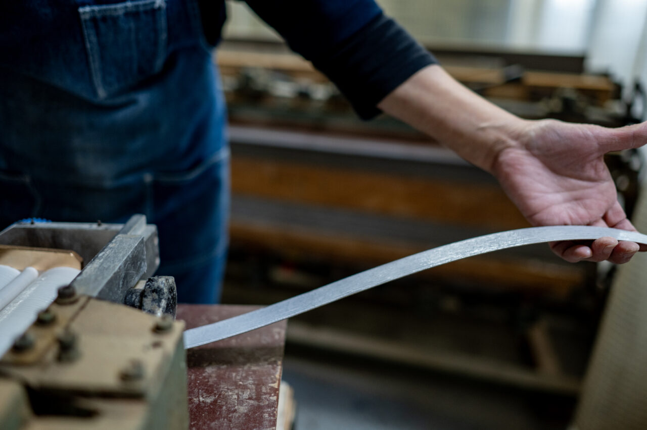 Spreaders (gluing machines) applying adhesive to long wood pieces for veneering.