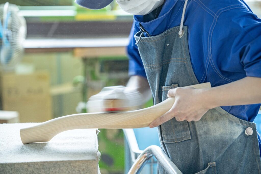 株式会社スズハルの木製猫脚家具、サンディングペーパーを使った手作業での仕上げ作業の様子