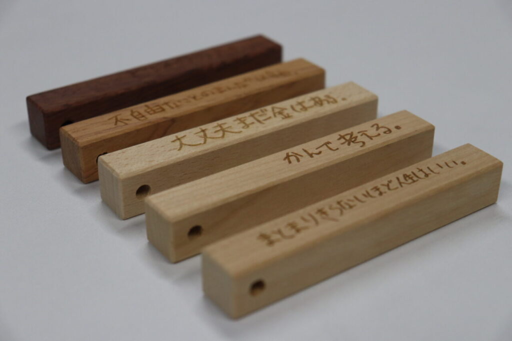 HAHAHANOLABOの木製言葉のキーホルダーの製品画像。さまざまな言葉が刻まれた木製キーホルダーが並べられたコトバ一覧。