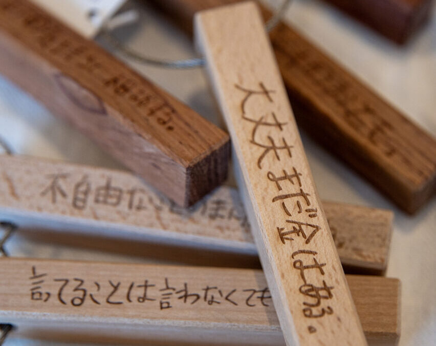 HAHAHANOLABOの木製言葉のキーホルダー。木の質感とシンプルなデザインが特徴的なキーホルダーで、さまざまな言葉が彫刻されています。