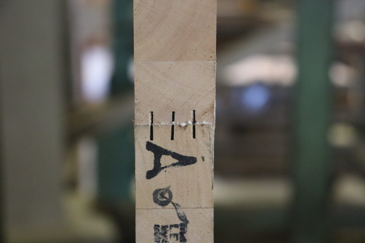 木工プレス機を使ってテーブル天板の木材を接合する作業の様子