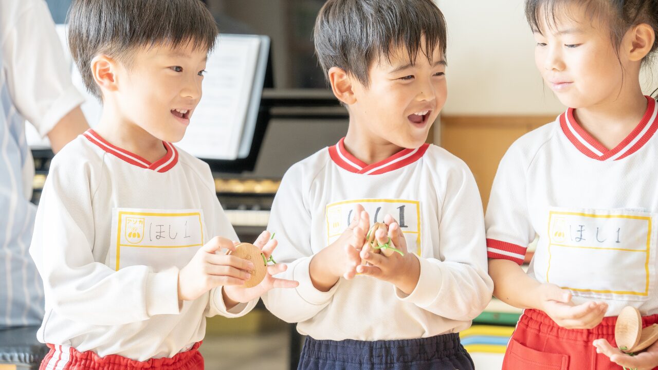 株式会社スズハルの音育カスタネット『あそおと』を手に、笑顔で演奏する園児たち