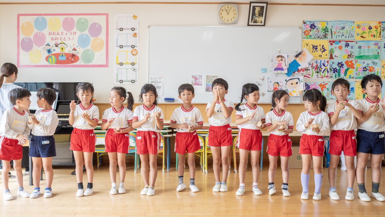 「アソカ学園城北幼稚園の園児たちが教室で、株式会社スズハルの音育カスタネット『あそおと』を手に持ち、楽しそうに演奏している様子
